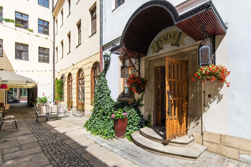 a building with a door and flowers in a street at Hotel Dwór Polski in Wrocław