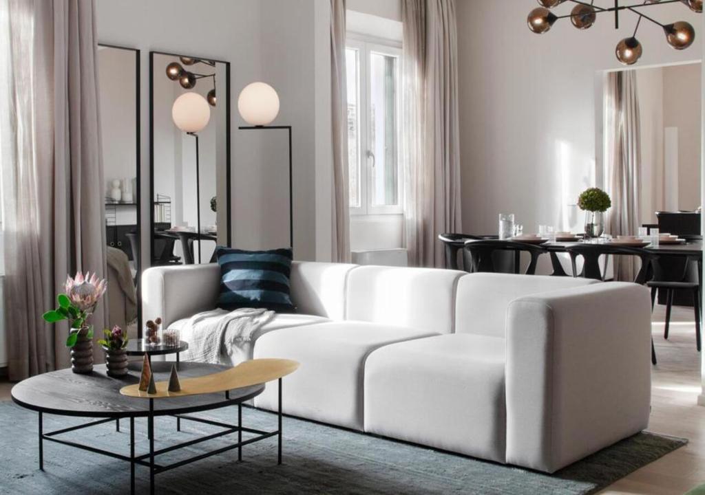 uma sala de estar com um sofá branco e uma mesa em BB Hotels Aparthotel Collection Il Michelangelo em Florença