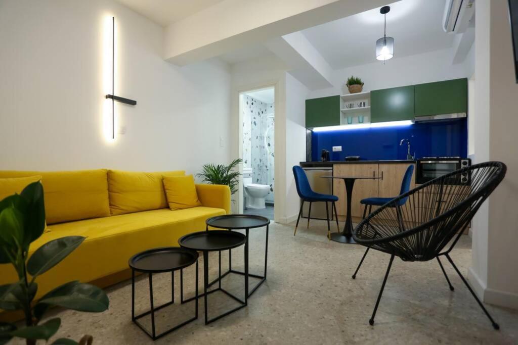 uma sala de estar com um sofá amarelo e cadeiras em Valory #4 Aesthetic Stay em Tessalônica