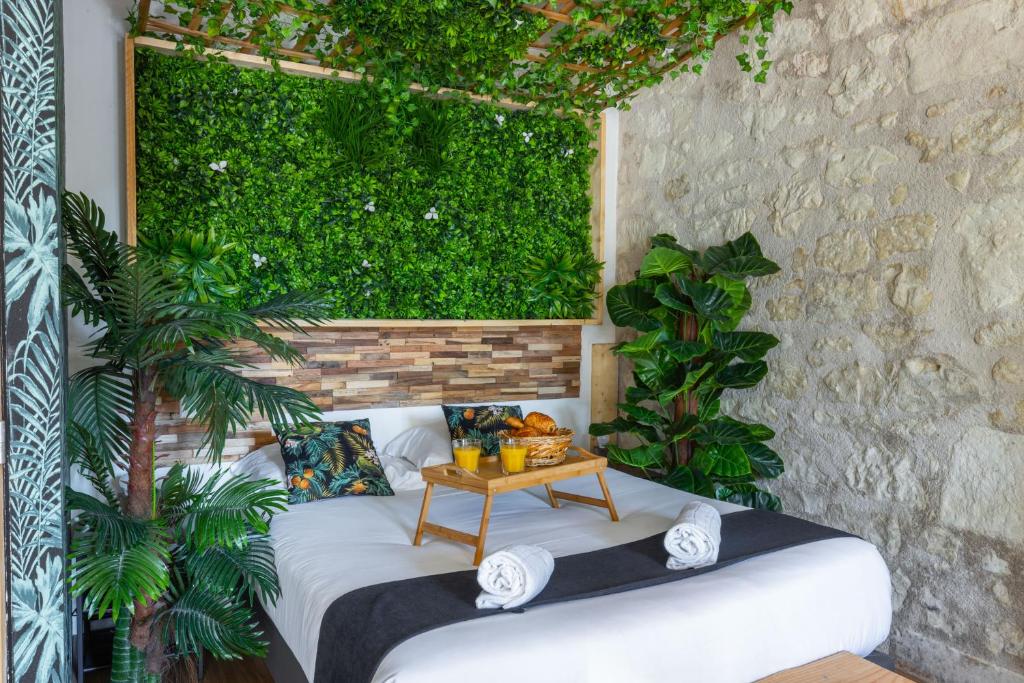 サン・テニャンにあるL'Amazonia - Domaine Tropicalの白いベッドと緑の壁が備わる客室です。
