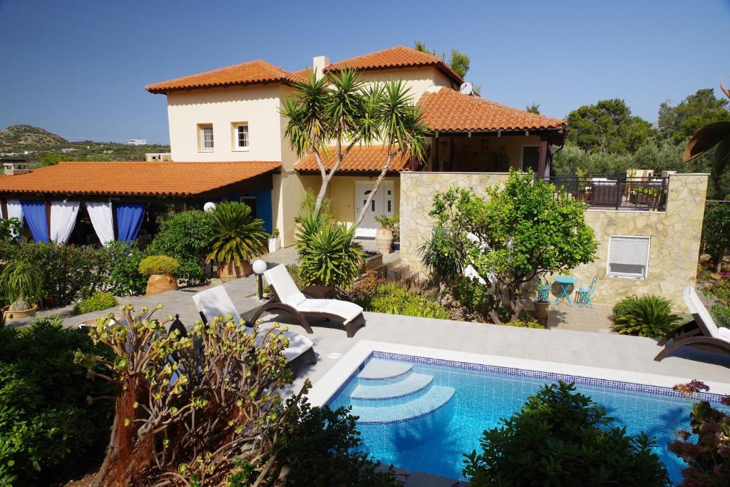 una casa con piscina frente a una casa en Villa Pegasus, en Agios Nikolaos