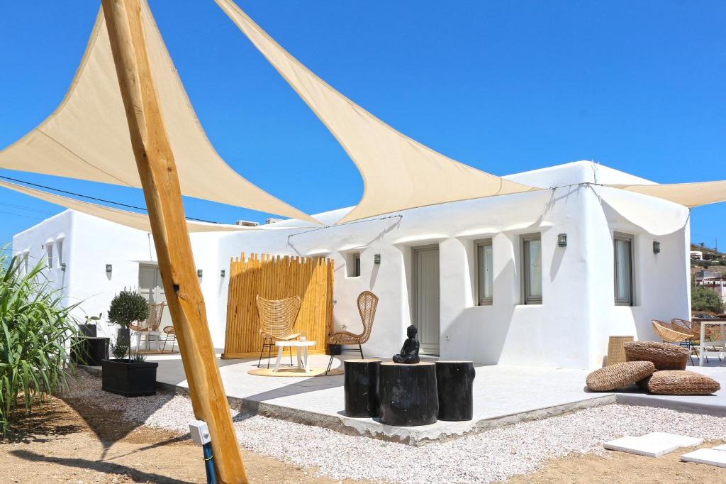 a white house with a blue and white umbrella at Enalion Suites in Mikonos