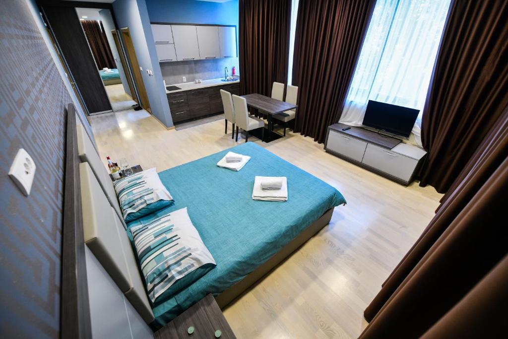 Cette chambre comprend un lit, une table et un bureau. dans l'établissement La Casa Apartments, à Banja Luka