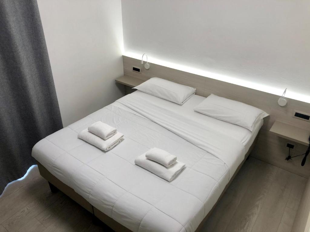 un letto bianco con due cuscini bianchi di B&B Hotel Roy a Silea