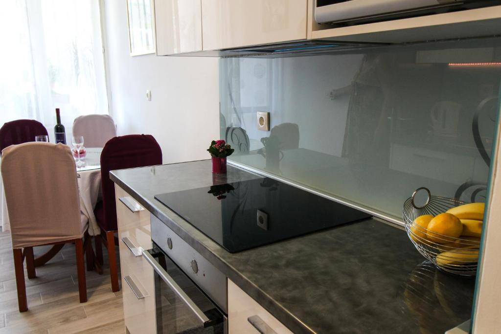 a kitchen with a counter with a bowl of fruit at Apartman Alka in Sinj