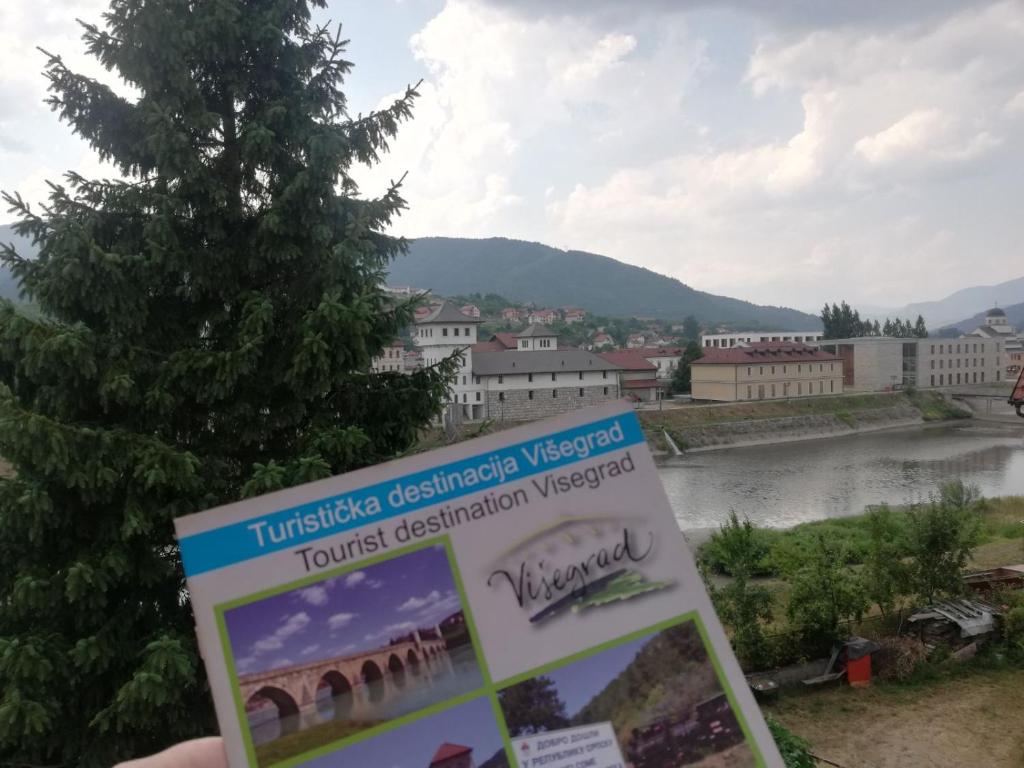 a sign in front of a view of a river at Apartmani Bambola in Višegrad