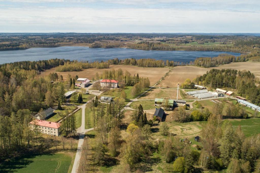 einen Luftblick auf einen Bauernhof und einen See in der Unterkunft Vääpeli in Hämeenlinna