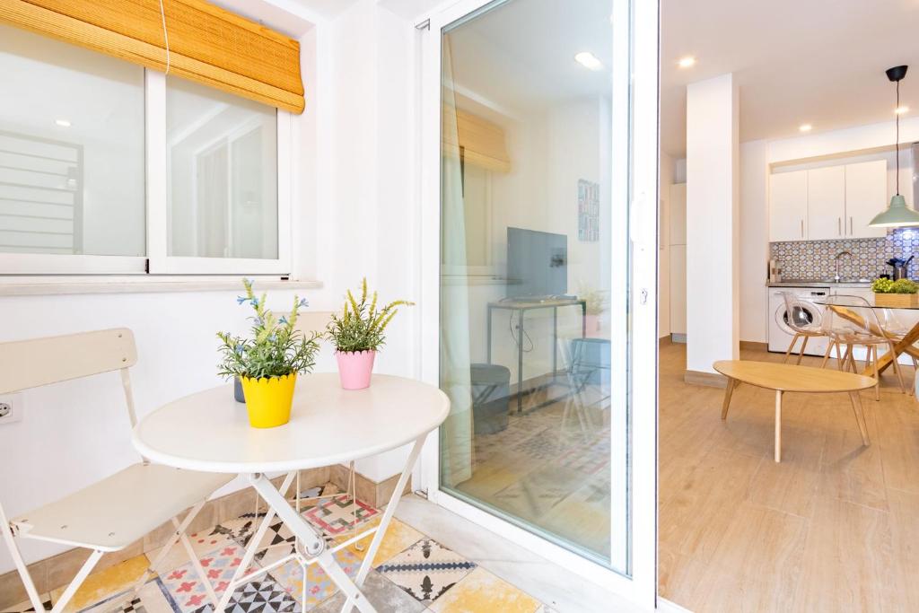 a kitchen and living room with a white table and chairs at Nine O'Clock Metrosol by Valcambre in Seville