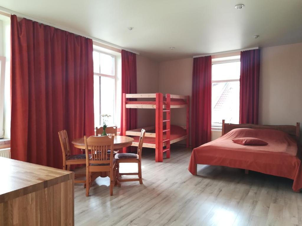 a bedroom with a bed and a desk and a table at Kuldiga Kalna Apartment in Kuldīga