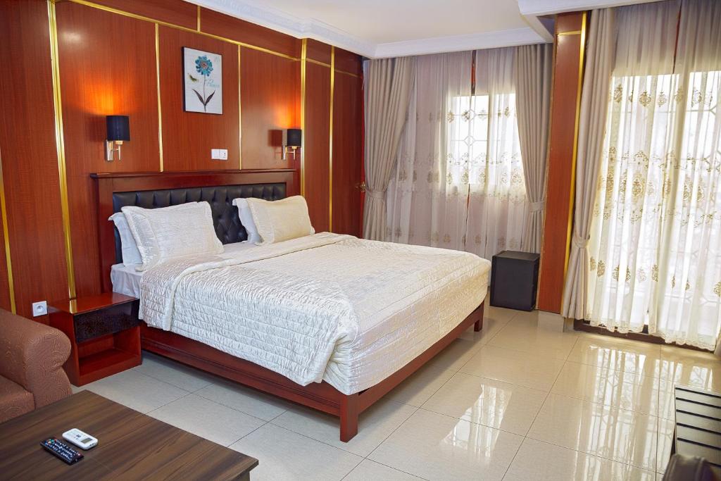 een slaapkamer met een groot bed in een kamer bij NOUBOU INTERNATIONAL HOTEL BONAPRISO in Douala