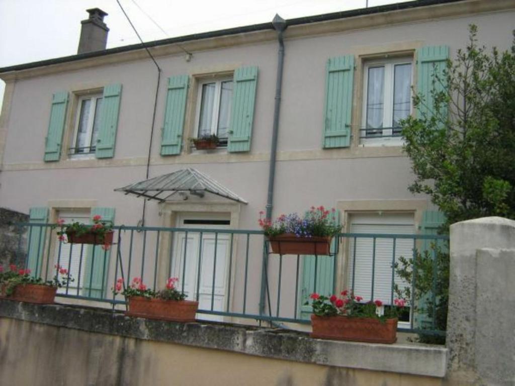 ein Gebäude mit grünen Fensterläden und Topfpflanzen in der Unterkunft Gîte Mécrin, 6 pièces, 10 personnes - FR-1-585-12 