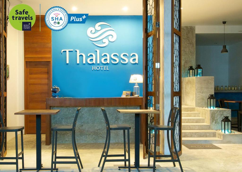 a bar with stools in front of a hotel at Thalassa - SHA Plus in Koh Tao