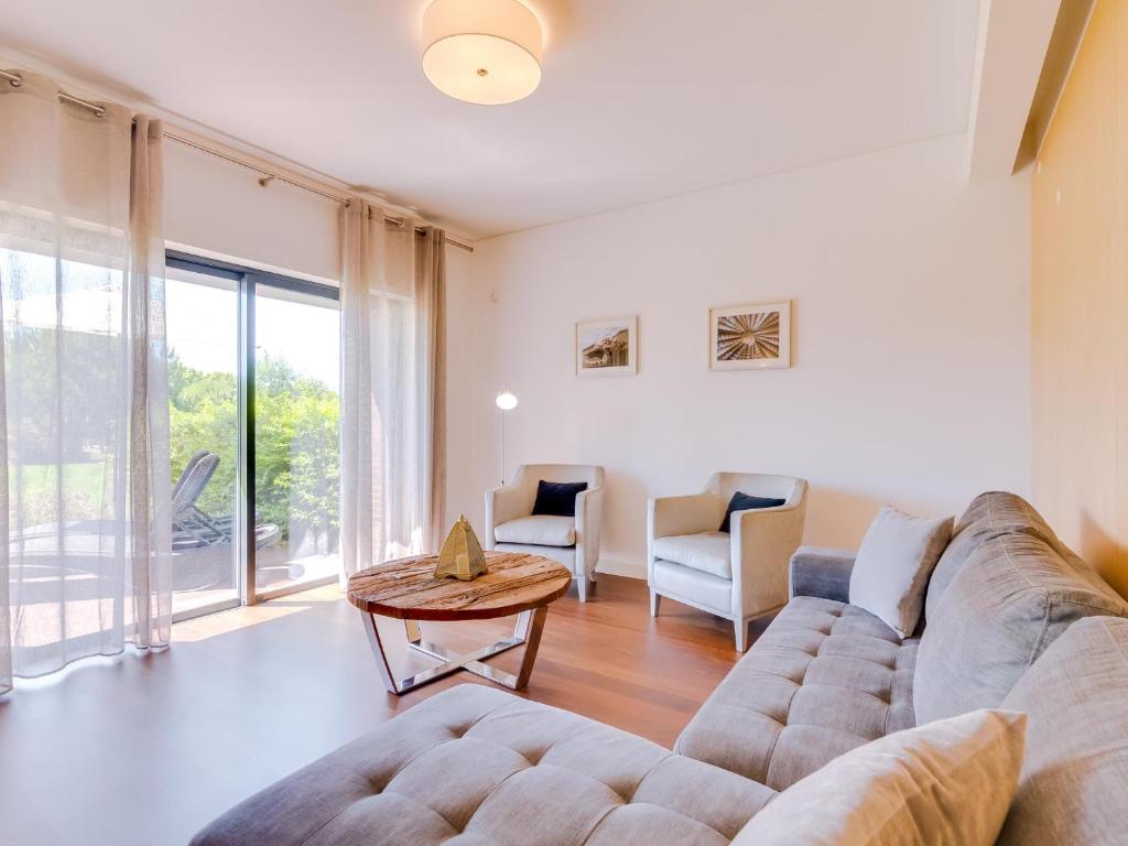 uma sala de estar com um sofá e uma mesa em AL - Apartamento L'Orangerie em Vilamoura