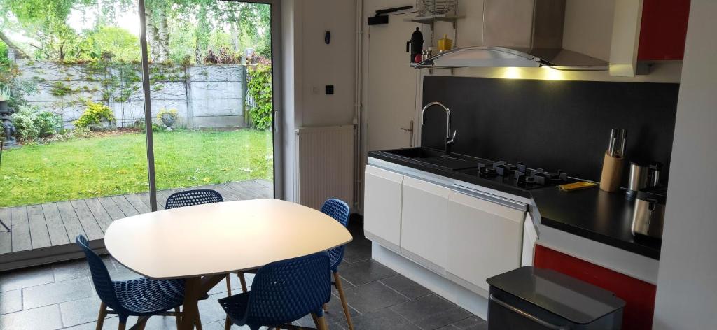 een keuken met een tafel en stoelen en een raam bij Maison de 3 chambres avec jardin clos et wifi a Vieux Conde in Vieux-CondÃ©