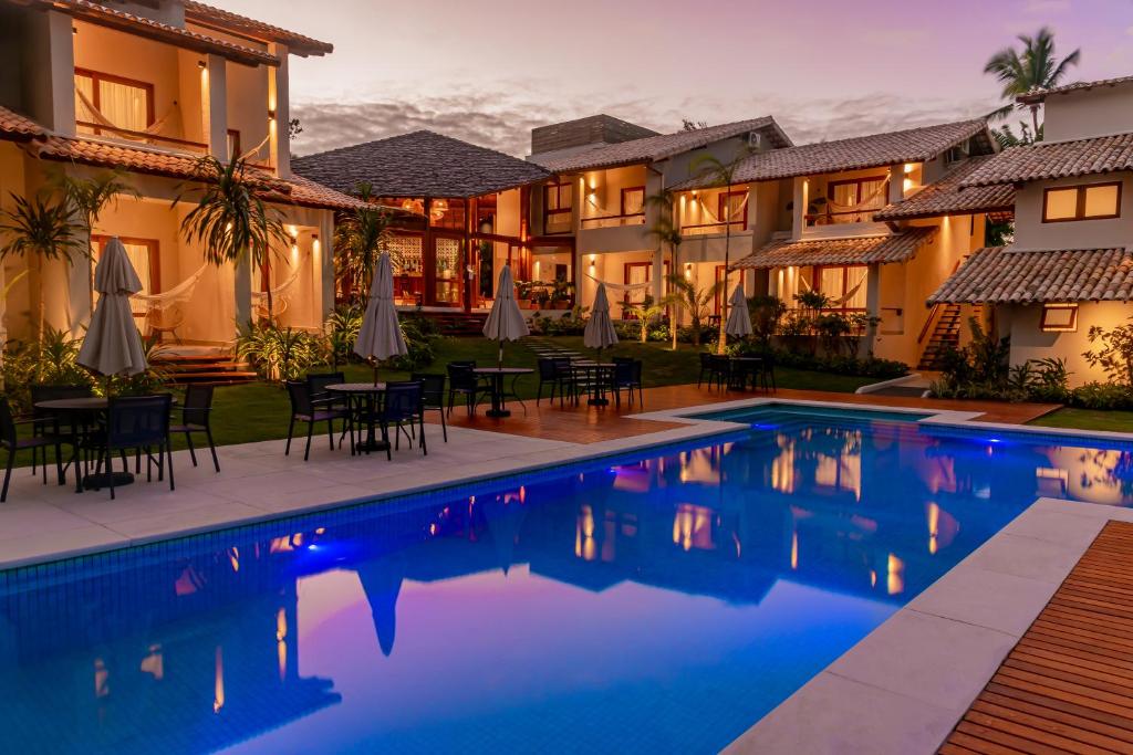 uma villa com piscina ao anoitecer em Hotel Paraiso do Morro em Arraial d'Ajuda