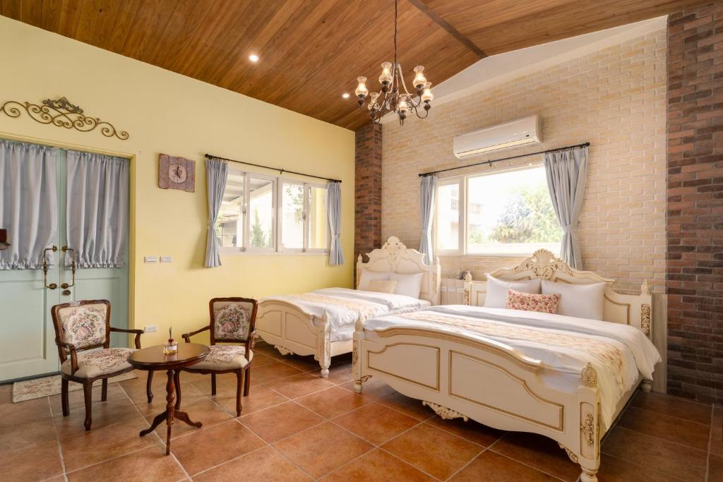 a bedroom with two beds and a table and chairs at Brulee&#39;s Done in Dongshan