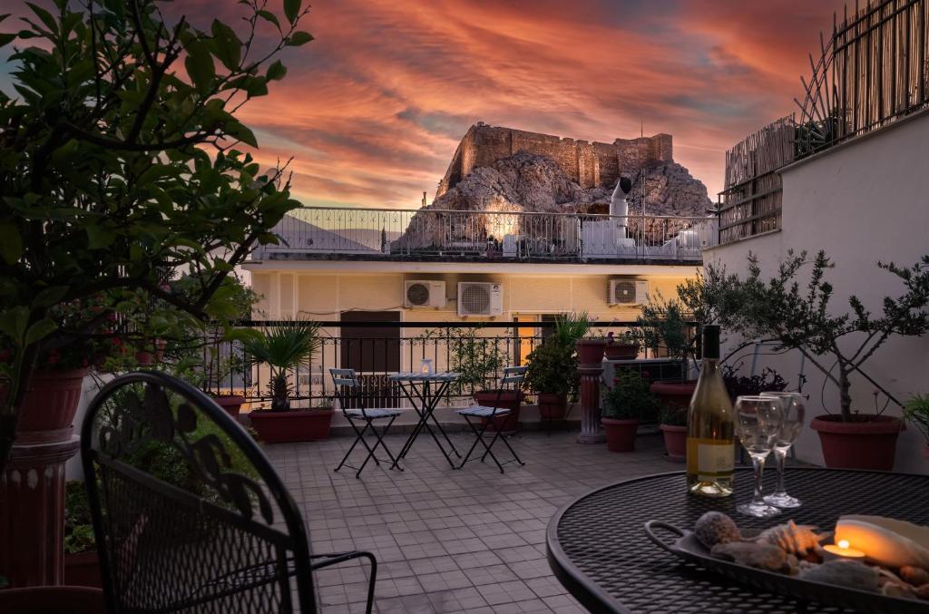 a patio with a table with a bottle of wine at ViLLA127 in Athens