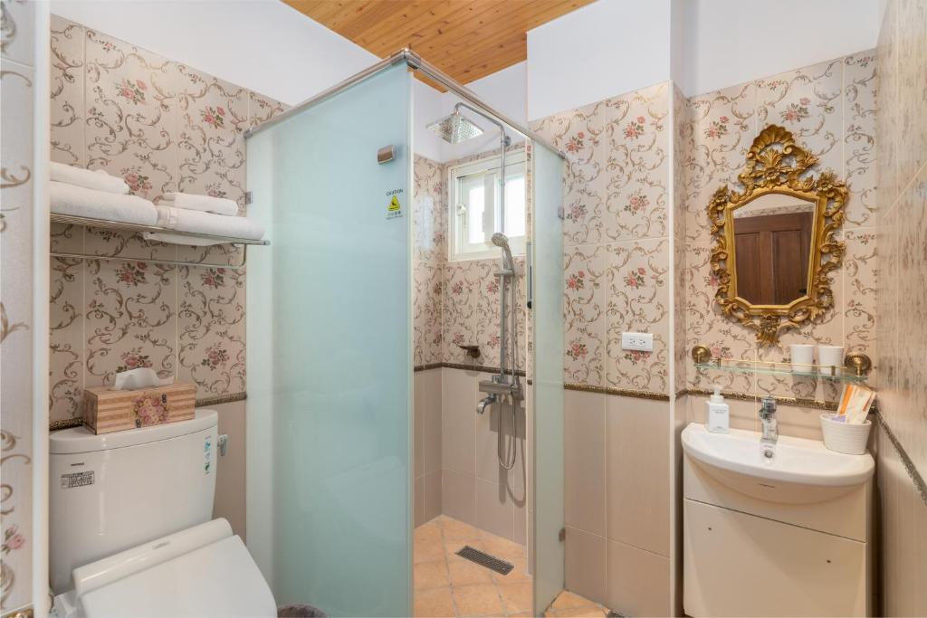a bathroom with a shower and a toilet and a sink at Brulee's Done in Dongshan