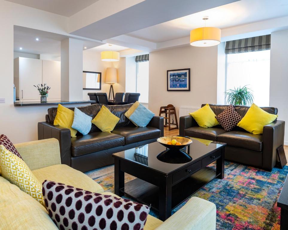 a living room with couches and a table at Inverness City Suites in Inverness