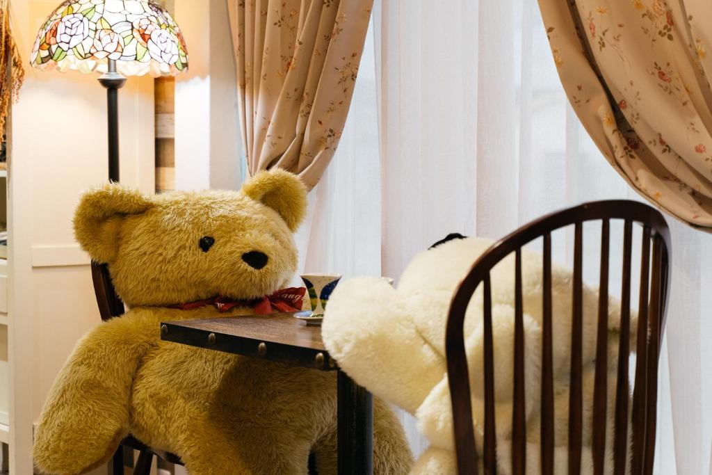 冬山鄉的住宿－布蕾頓民宿，一只泰迪熊和一只塞满动物坐在桌子上
