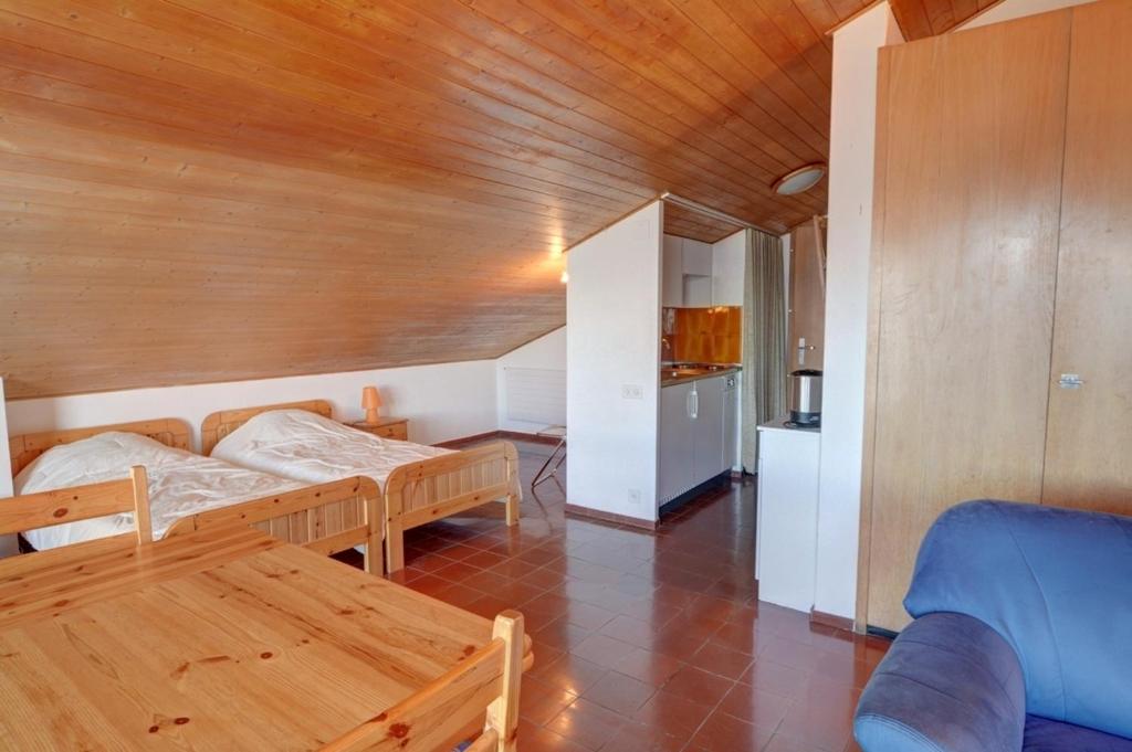アンゼールにあるApartment Mercure 501のベッド2台が備わる木製の天井の客室です。