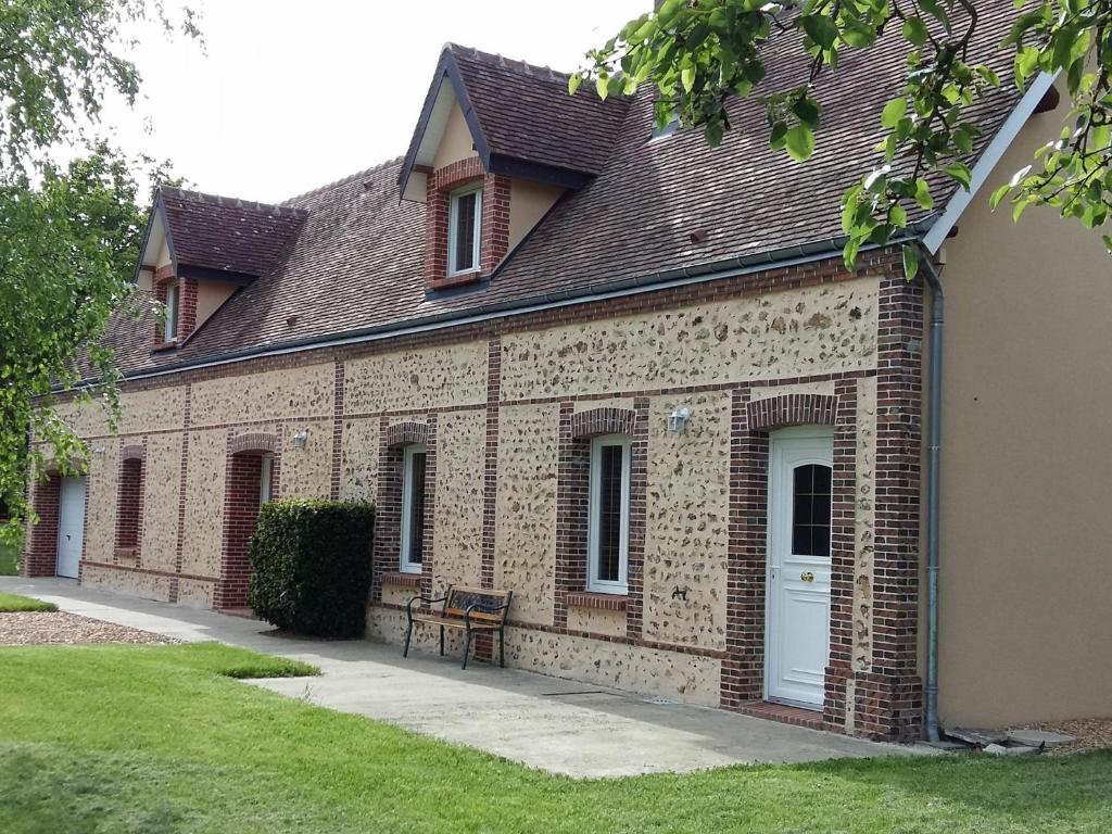 a brick building with a white door and a bench at Gîte spacieux en pleine campagne avec grand terrain, équipements de loisirs et confort moderne - FR-1-581-59 in Happonvilliers