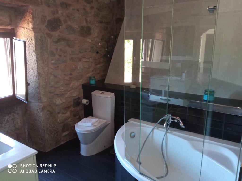 a bathroom with a tub and a toilet and a sink at Casa O Gures in Serantes