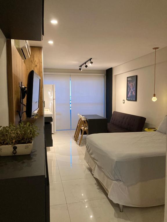 a bedroom with a bed and a couch and a tv at Studio Lux West Flat in Mossoró