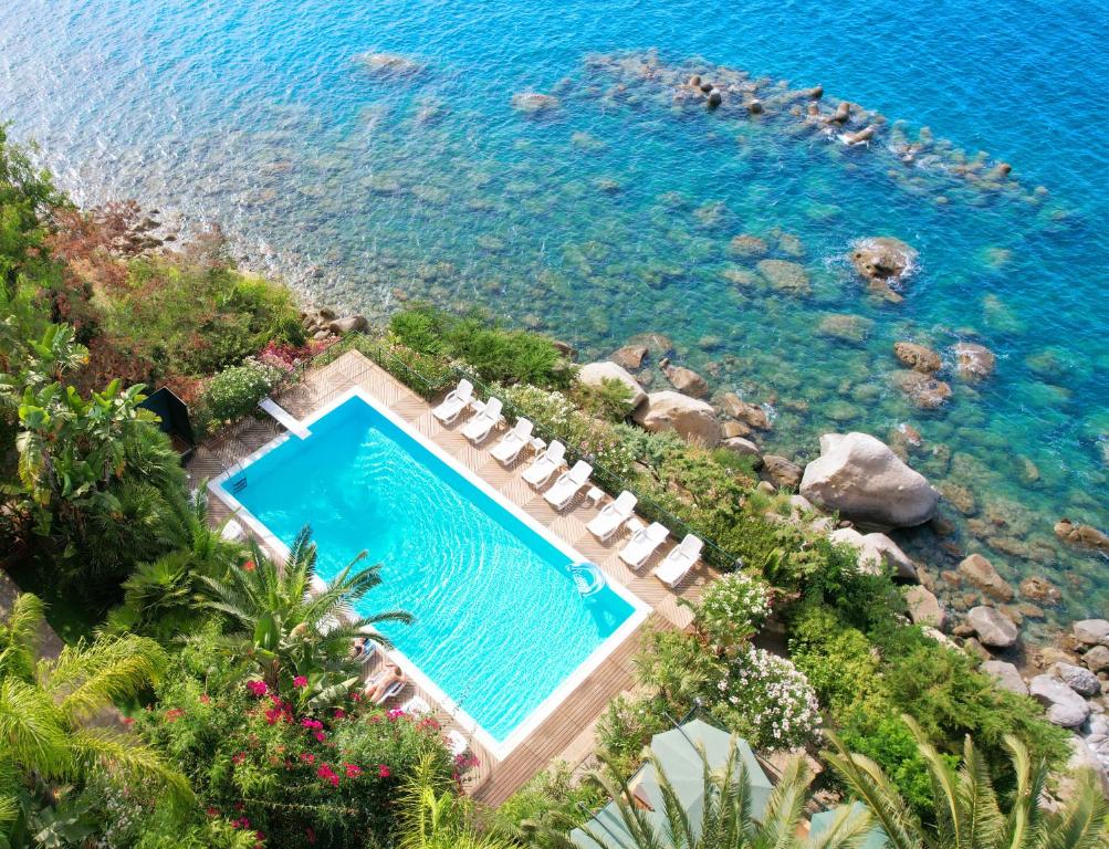 einen Luftblick auf einen Pool neben dem Wasser in der Unterkunft Villa Anita Apartments in Capo dʼOrlando