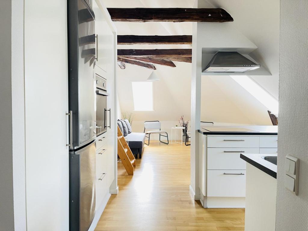 a kitchen with white cabinets and a ceiling with beams at aday - City Central Mansion - 4 bedroom apartment in Aalborg