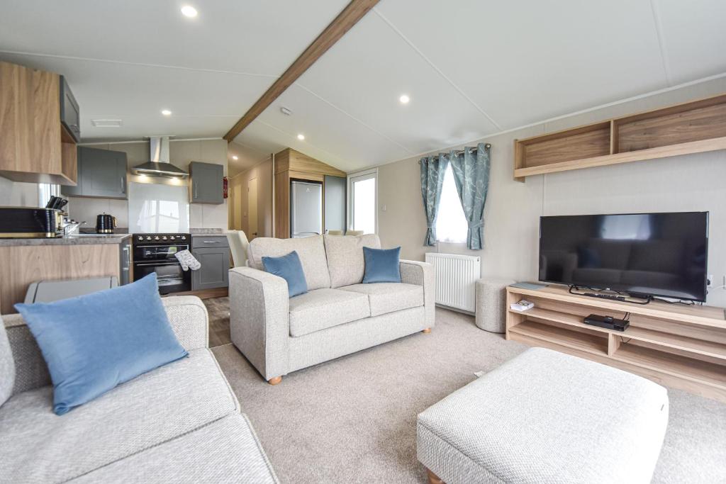 a living room with a couch and a flat screen tv at Hope View at Ashbourne Heights in Ashbourne