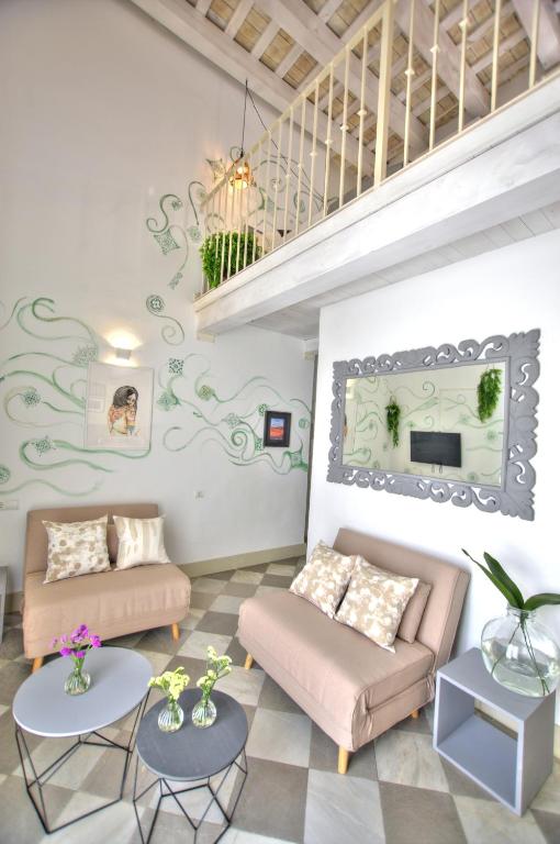 a living room with two couches and a staircase at La Casa de la Favorita in Tarifa