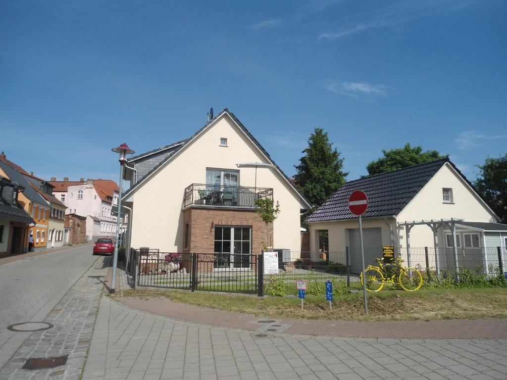 een wit huis op een straat met een stopbord bij Altstadt-Insel in Rathenow