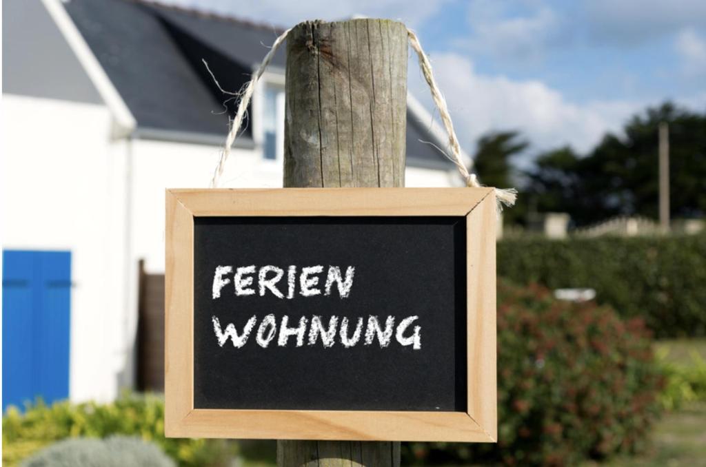 un cartel en un poste de madera con las palabras quince lloriqueando en Ferienwohnung Osnabrück- Schinkel, en Osnabrück