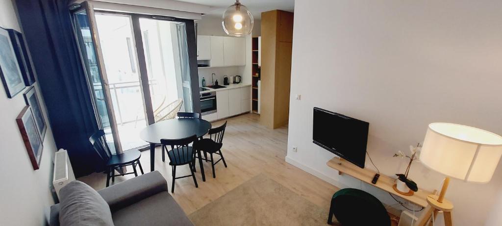 a living room with a couch and a table with chairs at Central Apartments Ogrody 2 & Parking in Gdańsk