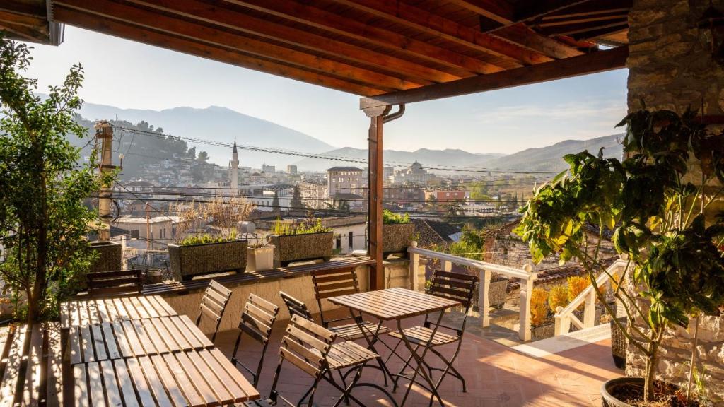 a balcony with tables and chairs and a view of the city at Hotel Borklad in Berat