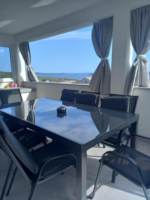 a table and chairs in a room with a window at Holiday home Petra in Vinišće