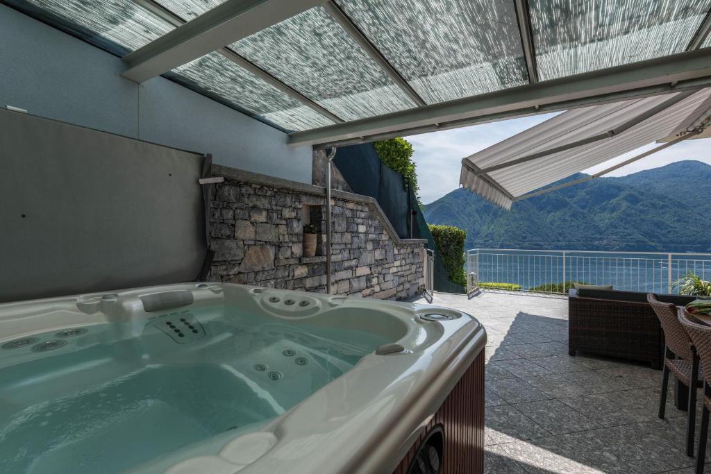 a jacuzzi tub on a patio with a view at Golfo di Venere in Lenno