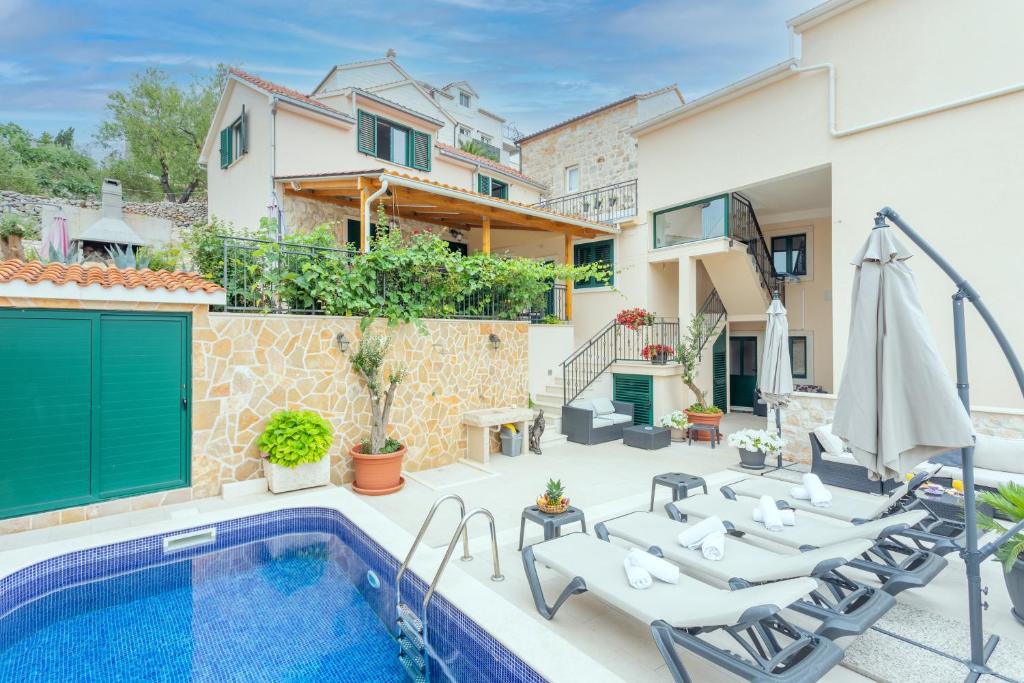 a villa with a swimming pool and a house at Apartments Ante in Hvar