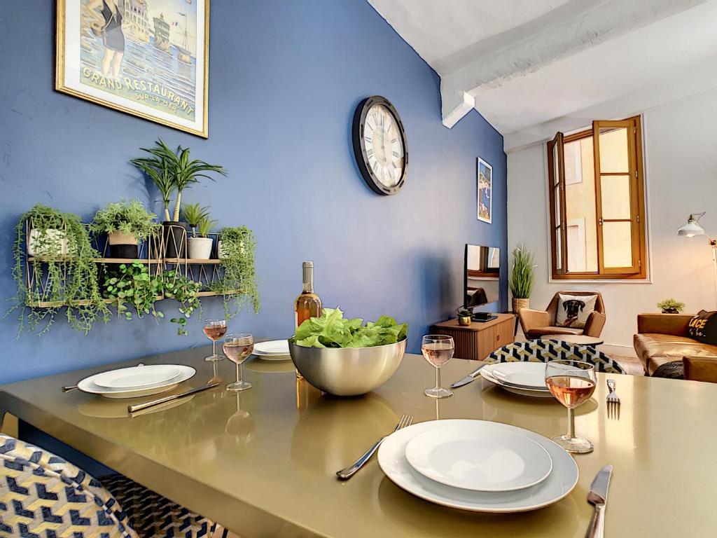 a dining room with a table with plates and wine glasses at Coeur Vieux Nice - Place Rossetti in Nice