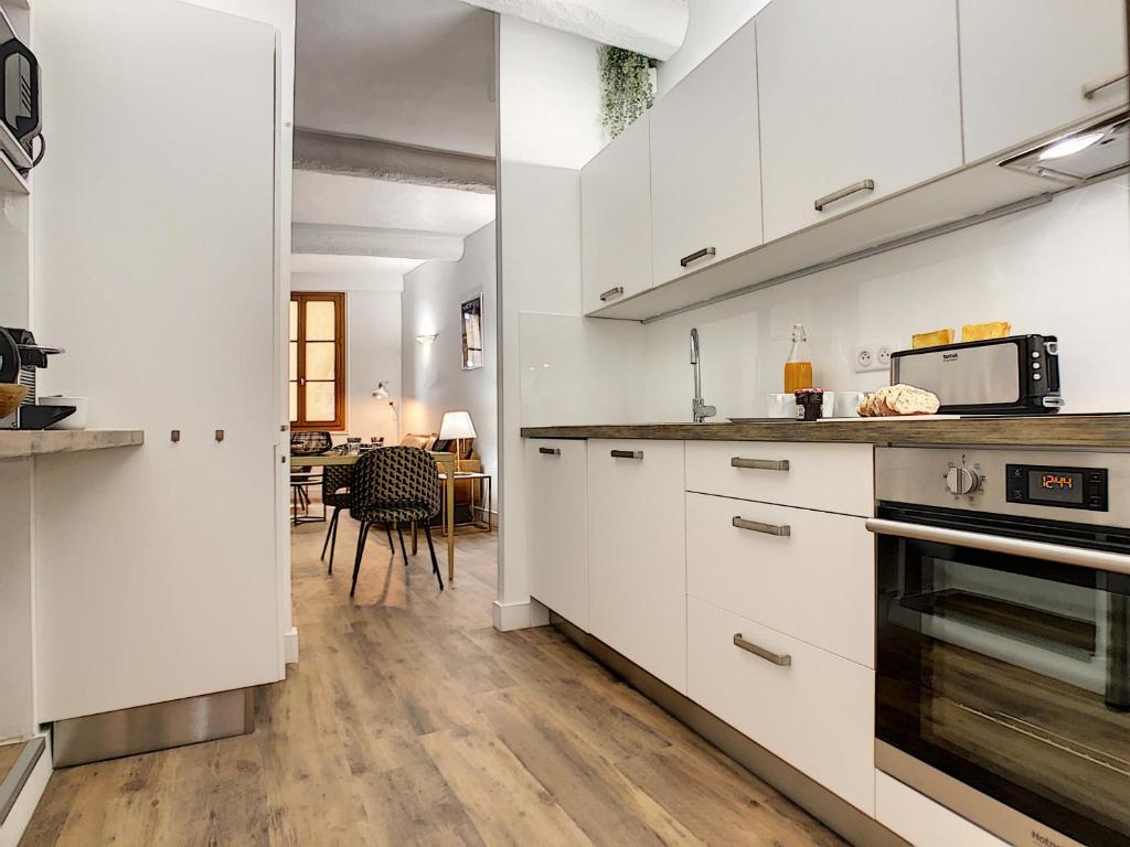 a kitchen with white cabinets and a counter top at Nestor&amp;Jeeves - DESIGN VIEUX NICE - Old Town - Close sea in Nice