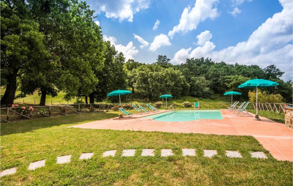 una piscina con sombrillas verdes en un parque en La Capannina, en Radicondoli