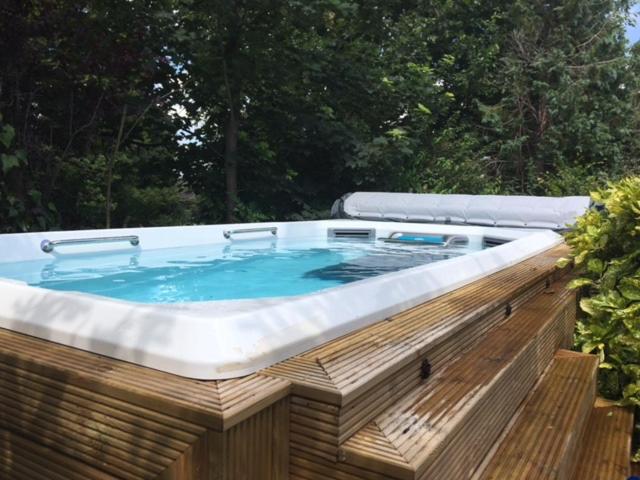 a jacuzzi tub in a wooden deck with at Harrogate boutique lodge with heated pool and hot tub in Staveley