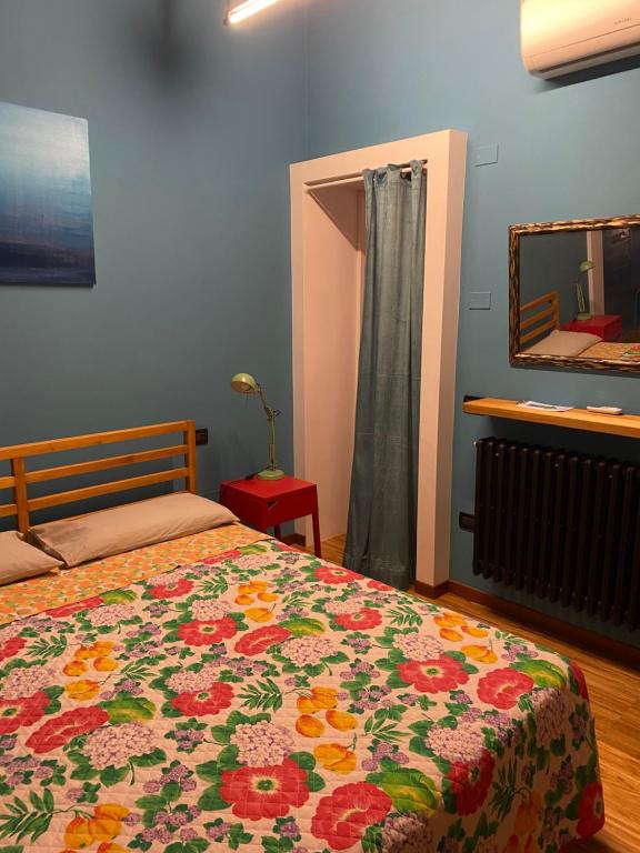 1 dormitorio con 1 cama con manta de flores en 62 B&B en Vicenza