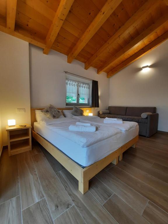 een slaapkamer met een groot bed in een kamer bij B&B alla Spiazzőla in Spormaggiore