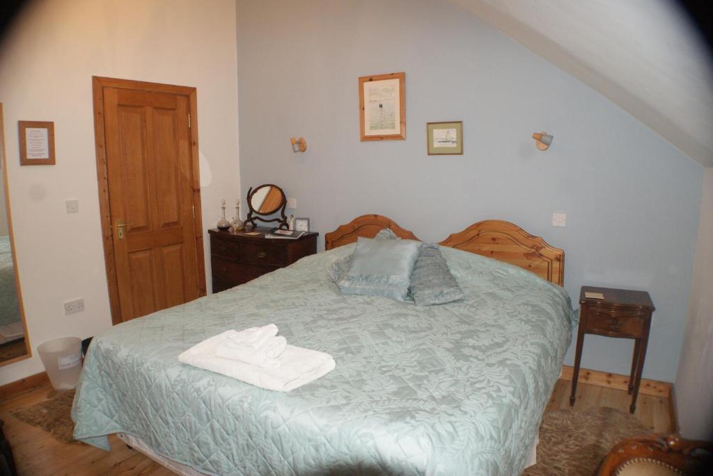 a bedroom with a bed with two towels on it at Knockaloe Beg Farm in Patrick