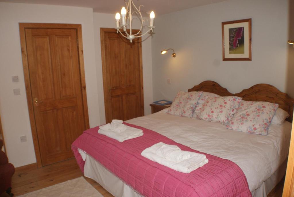 a bedroom with a bed with towels on it at Knockaloe Beg Farm in Patrick