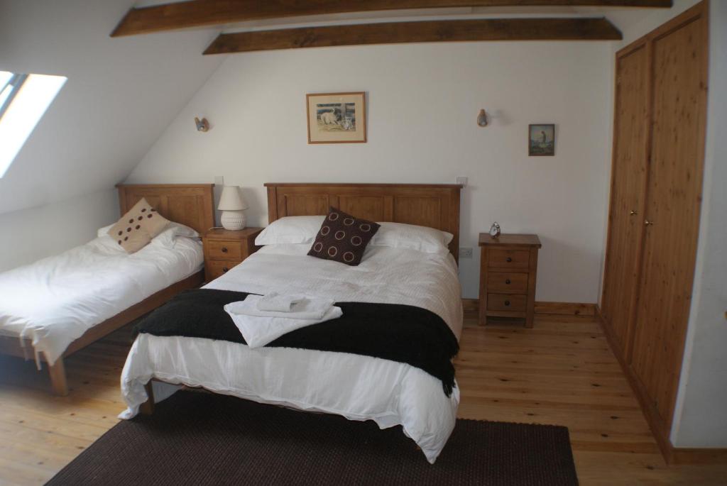 a bedroom with two beds in a room at Knockaloe Beg Farm in Patrick