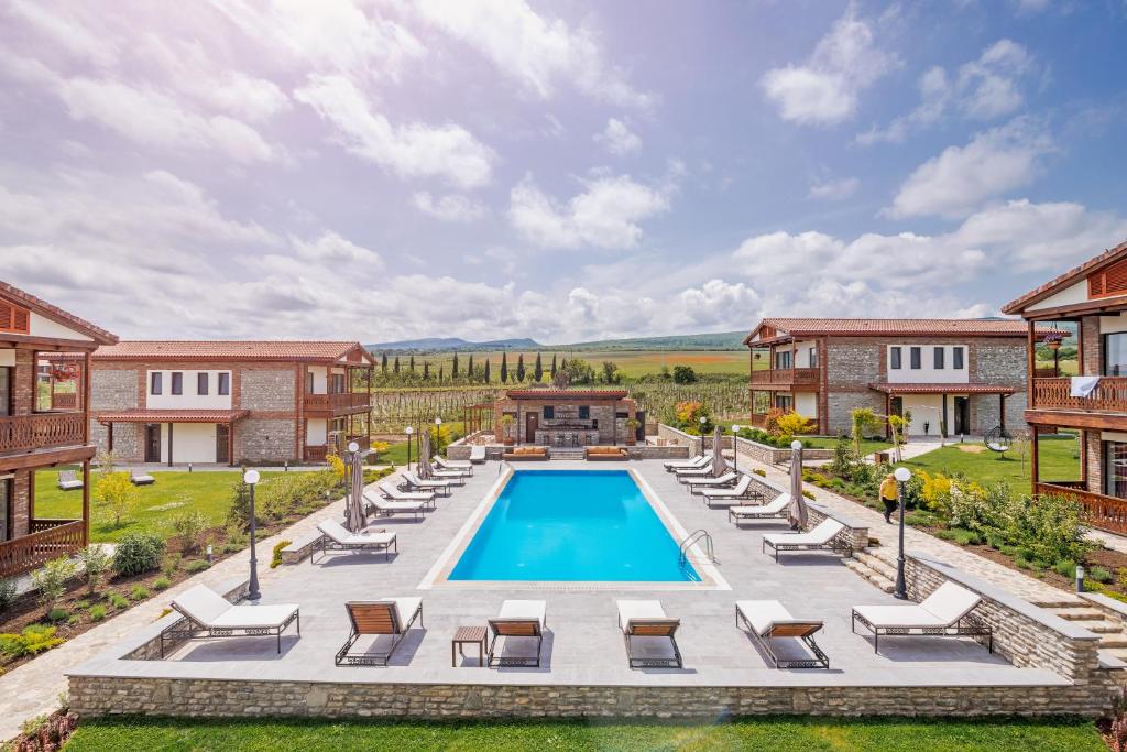 an estate with a swimming pool and lounge chairs at Château Mosmieri Hotel & Winery in Tʼelavi