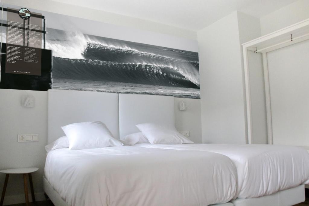 A bed or beds in a room at Apartamentos Mundaka Surf Camp